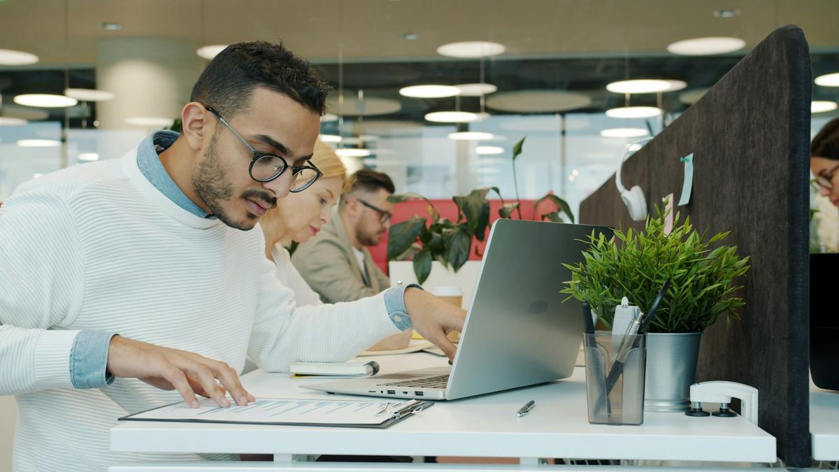 Profissional trabalha ao notebook numa mesa com plantas